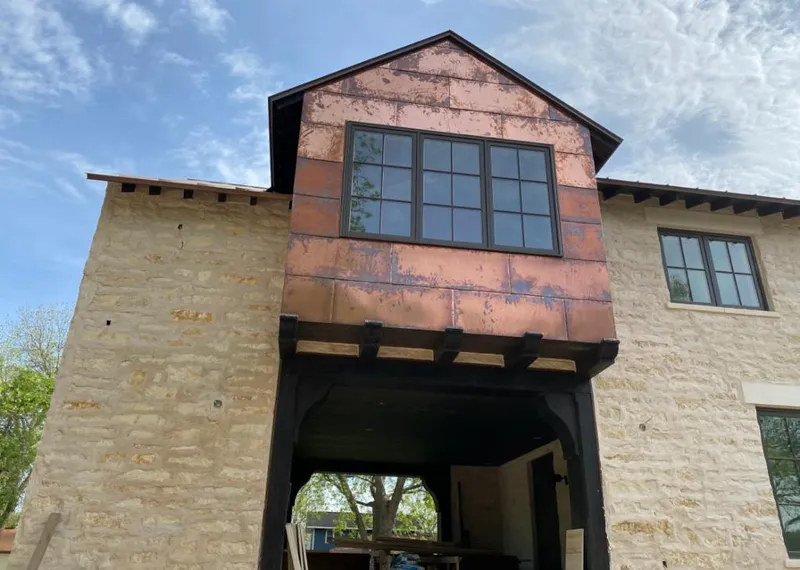 Copper metal panel facade on a stone building for Roof Repair in South Houston